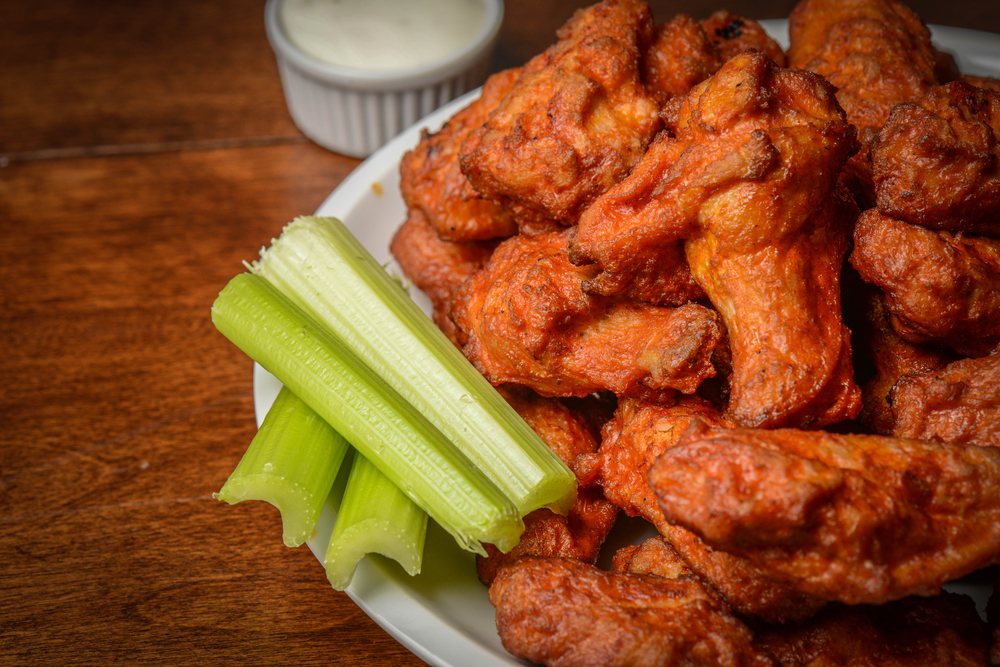 Chicken Buffalo Wings with Celery Sticks in a bowl on a table 