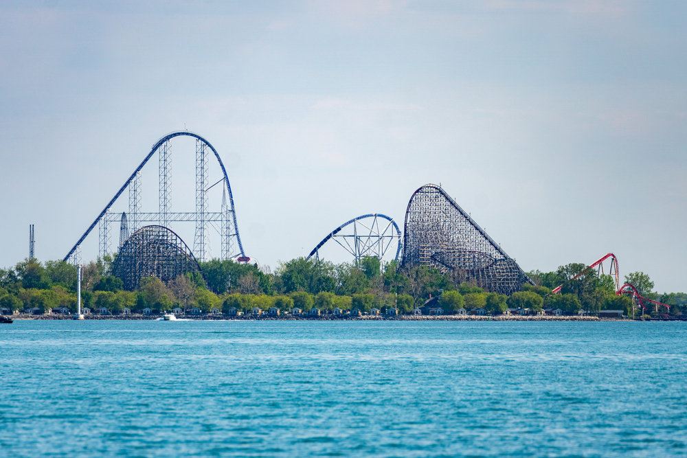 Distant view of a roller coaster ride with water in the front midwest attractions