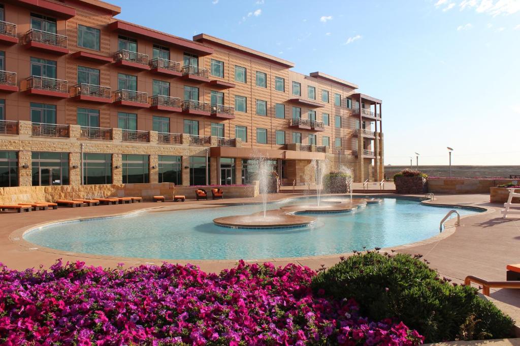 One of the resorts in Iowa. The picture shows a pool with fountains with flowers in the foreground and the hotel in the background.  