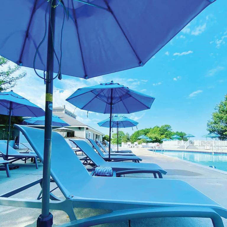 The side of a pool showing sun loungers and umberellas in an article about resorts in the Midwest