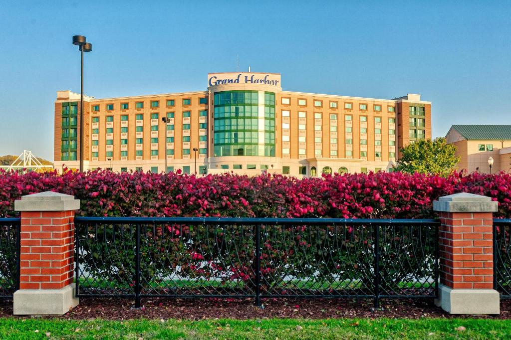 The Grand Harbor hotel with flowers and a fence in front of it. 