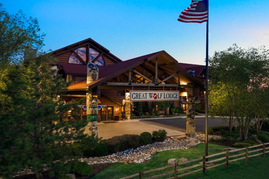 The outside of the Great Wolf Lodge which is a wooden building surrounded by trees and grass. 