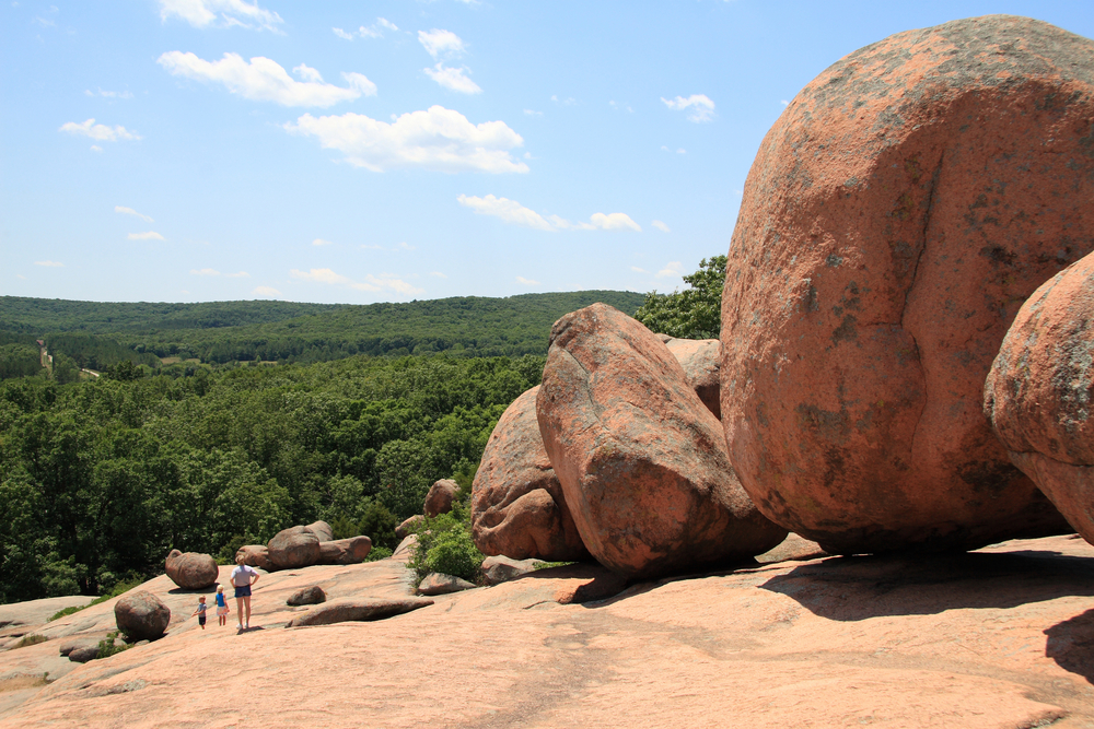 People hiking along the giant boulders in Elephant Rocks State Park in Missouri.