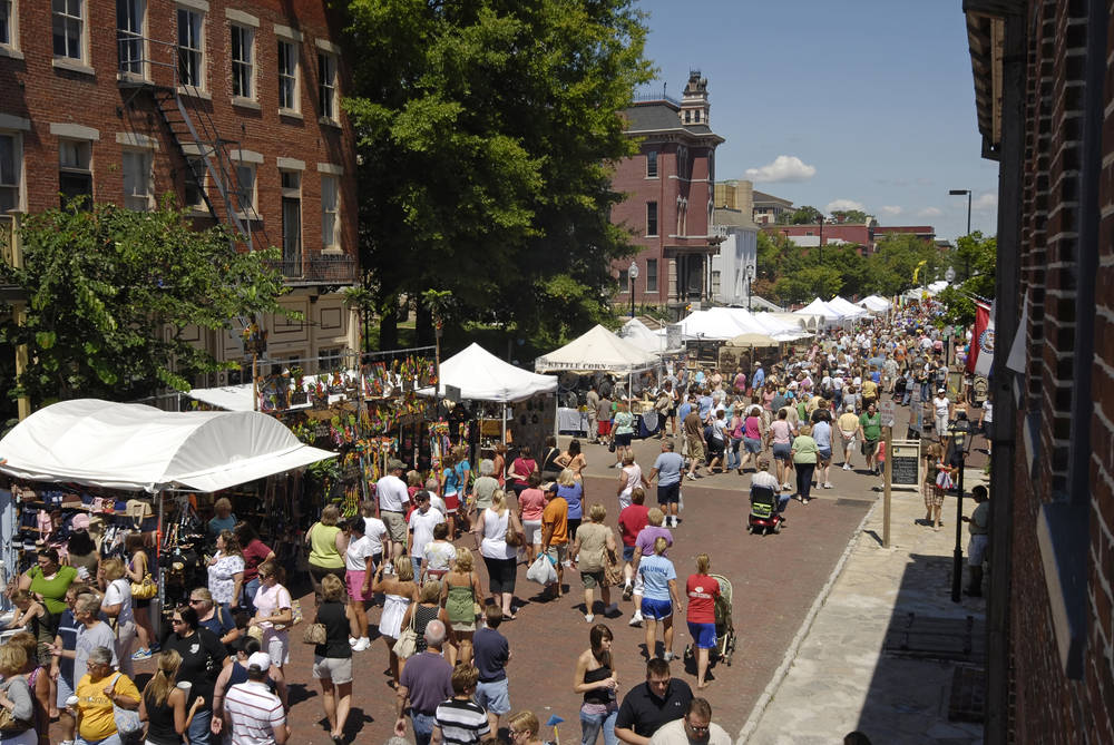 View looking down at a street crowded with people and vendor booths.