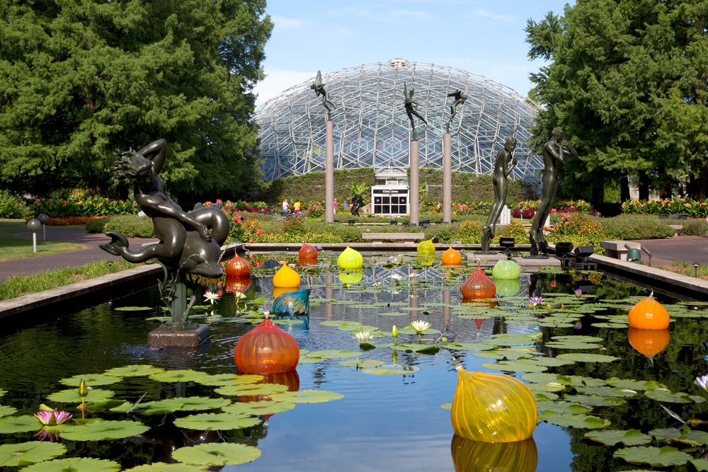 Lily pond with glass orbs and statues in front of the geodesic dome conservatory.