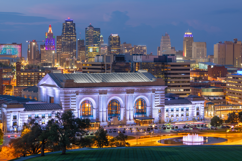 Union Station lit at night with the Kansas City Skyline in the background.
