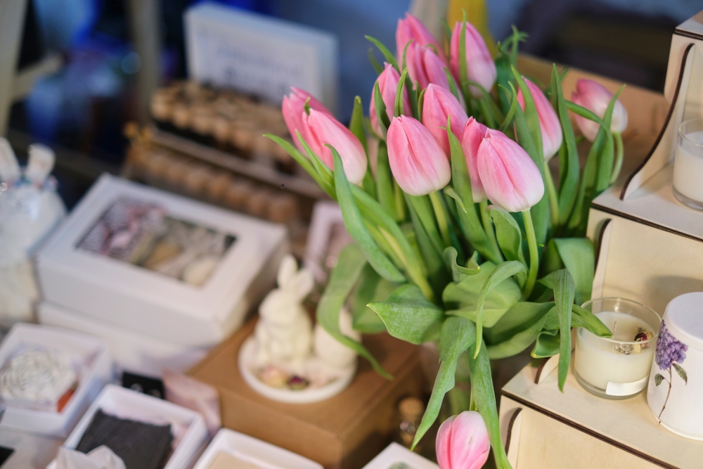 A table with pink tulips and handmade goods
