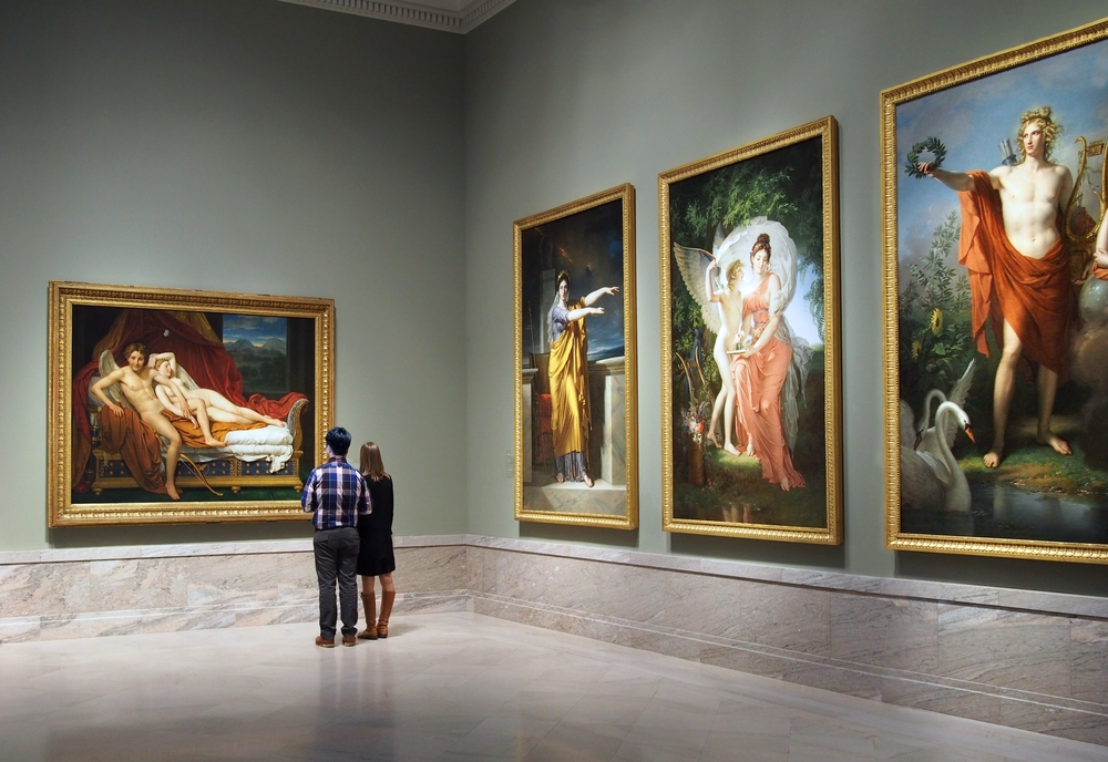 A couple looking at huge paintings of people in the Cleveland Museum of Art one of the best attractions in Ohio