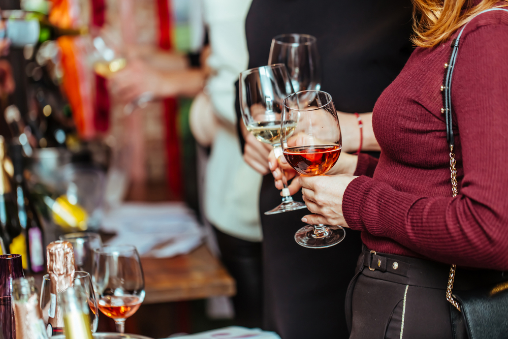 Wine tasting: visitors stand near tables with tasting samples and hold glasses of wine. The wine festivial is one of the events in Ohio. 