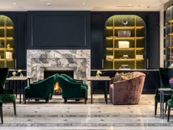 Sleek lobby of resorts in Illinois with gray marble floors and dark green chairs