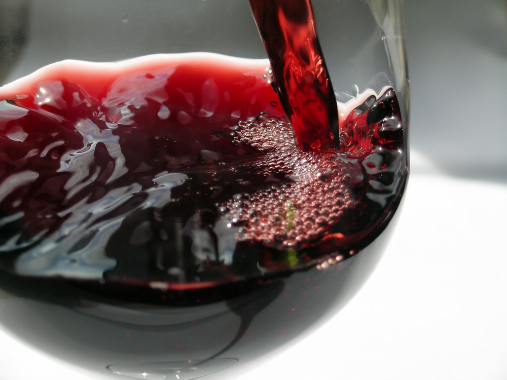 Red wine been poured into a glass close up. The article in about wineries in Illinois. 