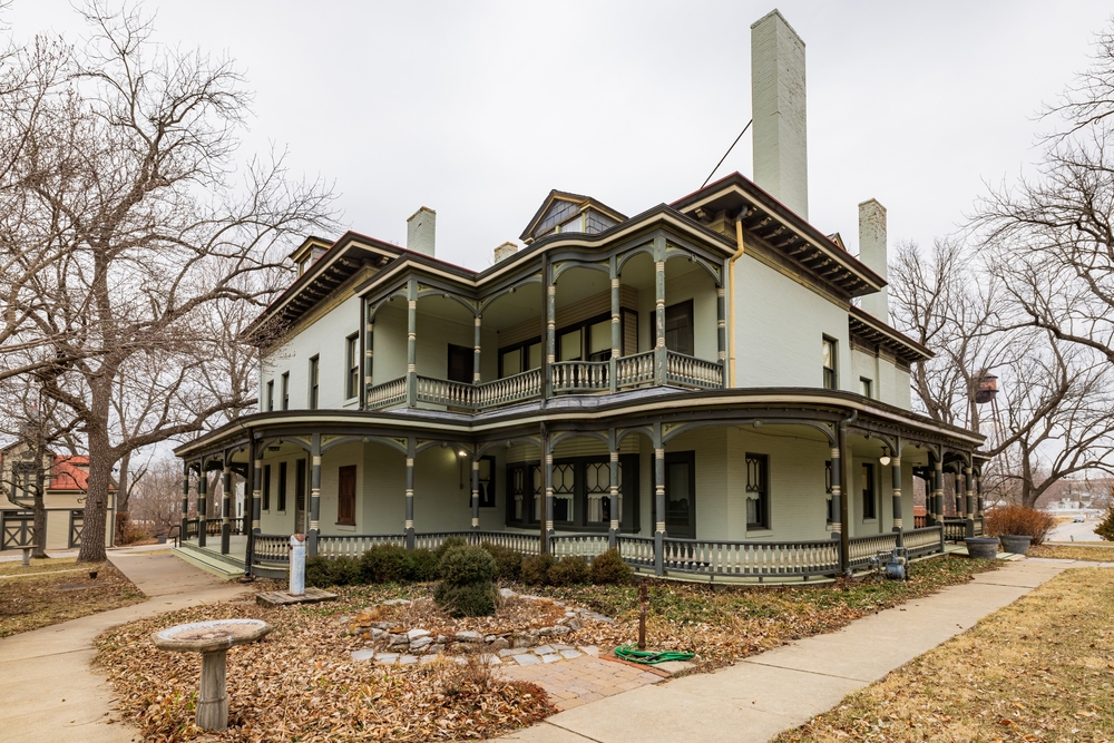 Two story Bingham-Waggoner Mansion with wrap around porch and balcony.