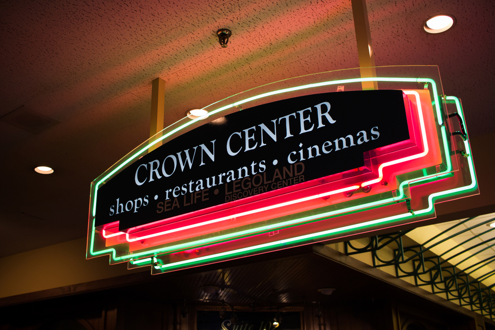Hanging neon sign reading, "Crown Center, shops restaurants cinemas."