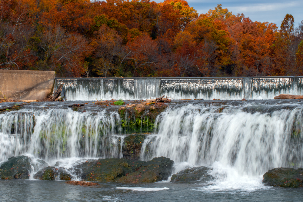 The tiered Grand Falls with red, fall trees in the background.