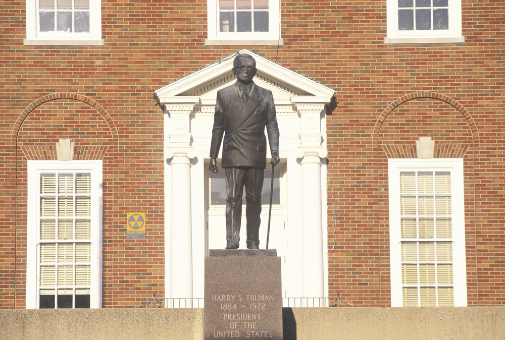 Statue of President Truman in front of a white door in the brick courthouse in Independence, MO.