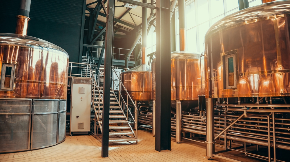 The inside of a distillery with copper equipment distilling whiskey