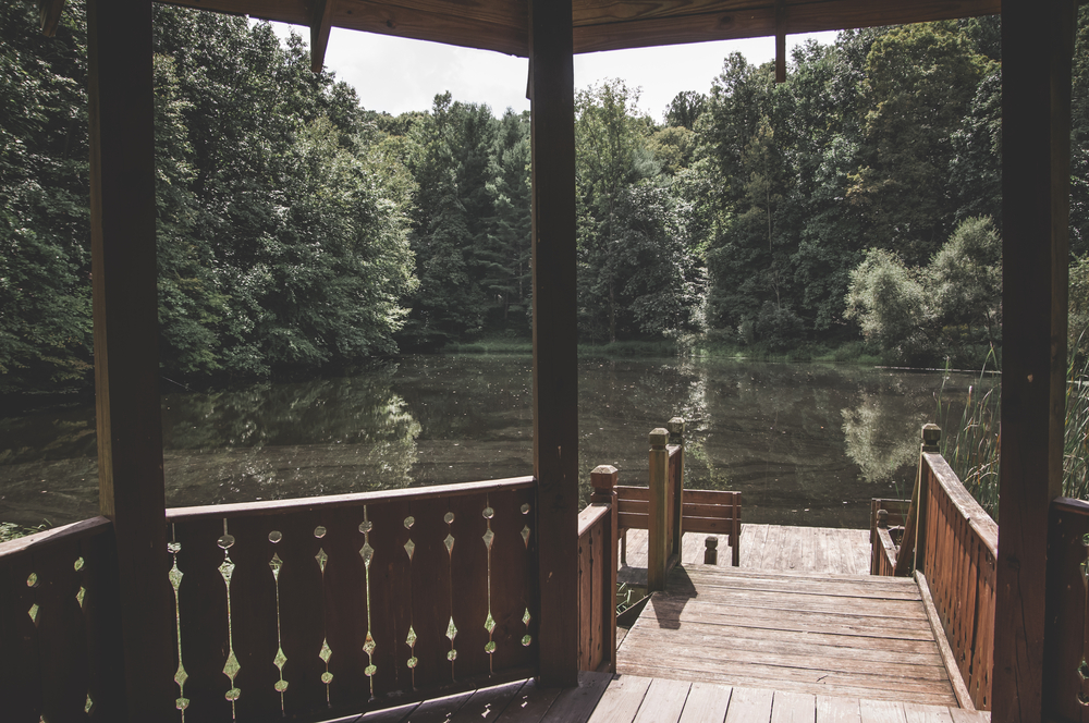 View from a gazebo with a wooden deck that overlook a forest lake on a summer day at Boch Hollow State Nature Preserve in Ohio