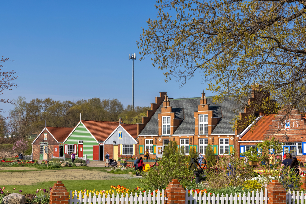 Row of colorful Dutch-styled houses and flowers at Windmill Island Gardens, one of the best things to do in Holland, MI.