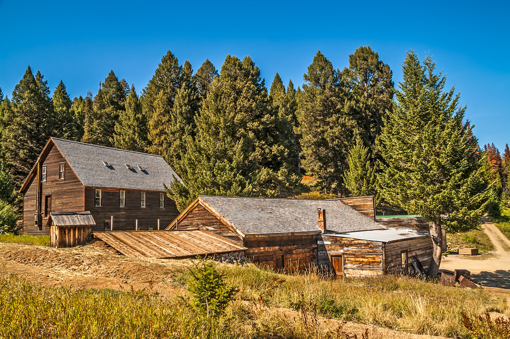 Preserved wooden buildings at Garnet Ghost Town with trees behind them.