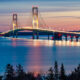 Sunset over the lake and lit up Mackinac Bridge, one of the best attractions in Michigan.