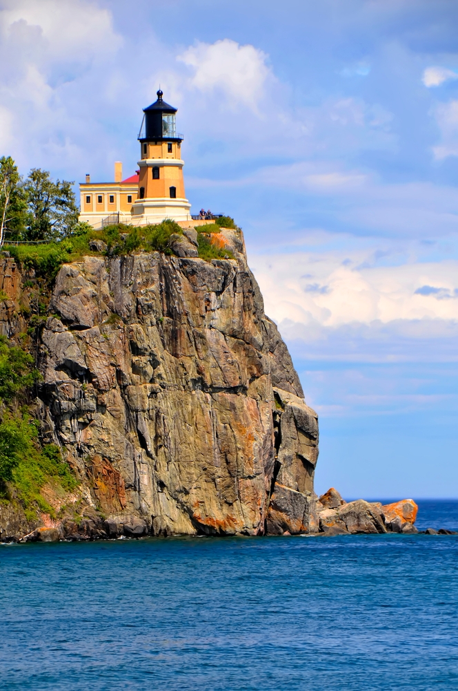 Split Rock Lighthouse sitting atop a rocky, sheer cliff overlooking the lake.