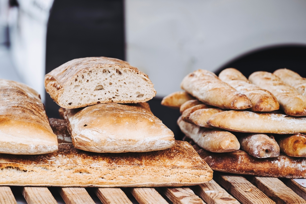 Artisanal bread baguettes placed on a market stall