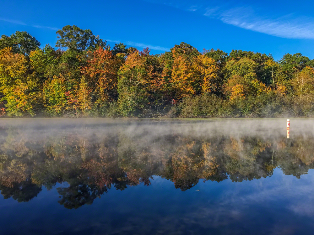 Sunny, fall day at Mirror Lake with light fog over the water reflecting the trees.