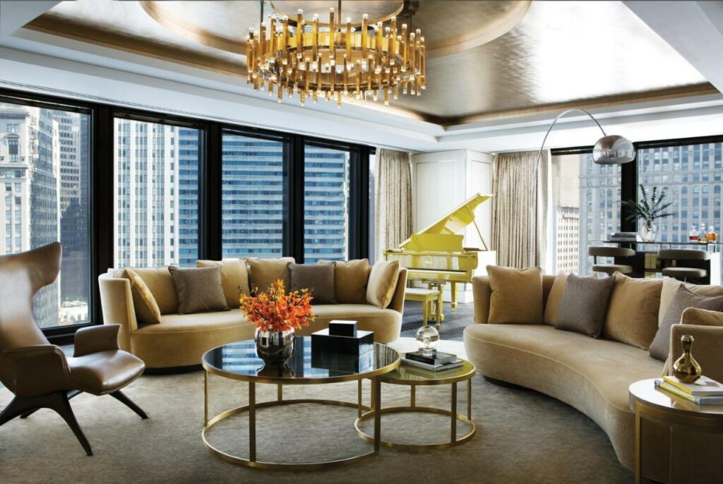 Lounge area at the Langham Chicago with couches, a chandelier, and a grand piano.