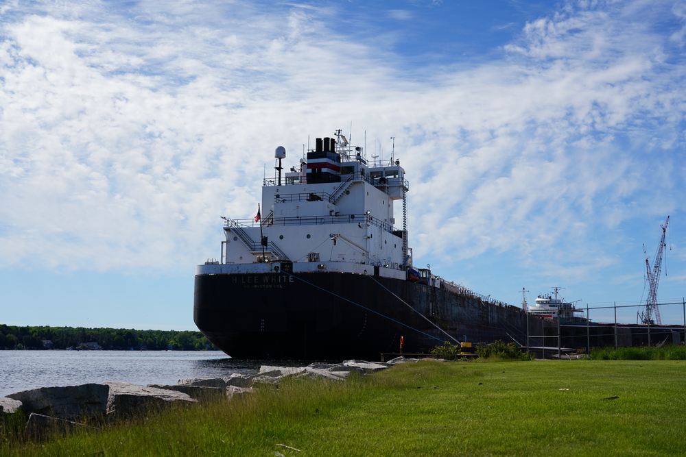 White diesel powered lake freighter sits docked at shipbuilding company for repairs. The shipyard does tours in spring. 