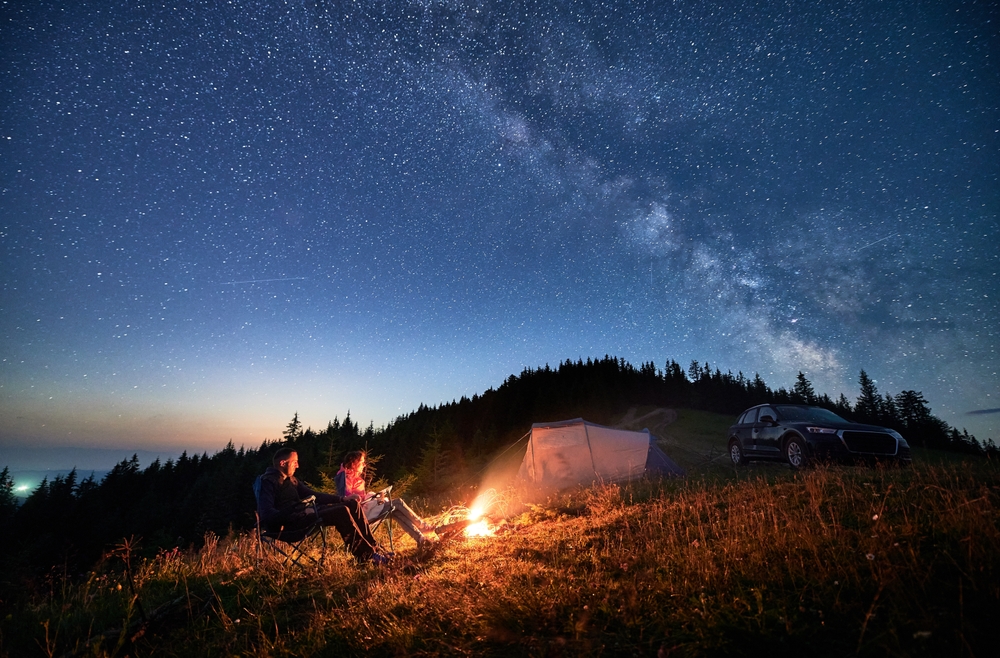 Night camping in the mountains under starry sky with Milky way.  One of the Midwest winter getaways