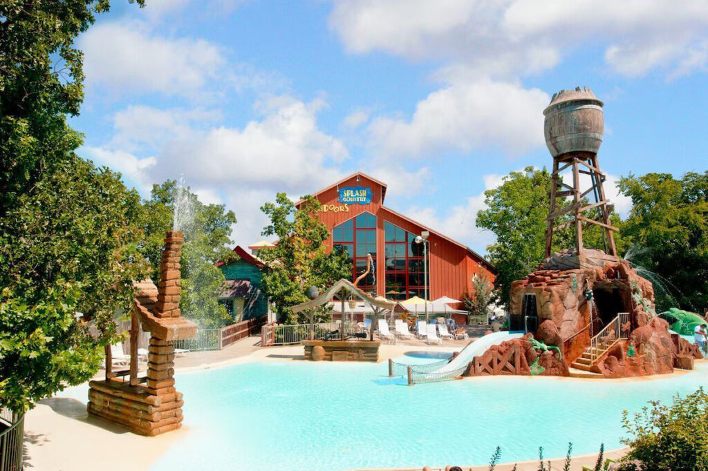 red building behind a waterfpark with pool and slide branson family resorts