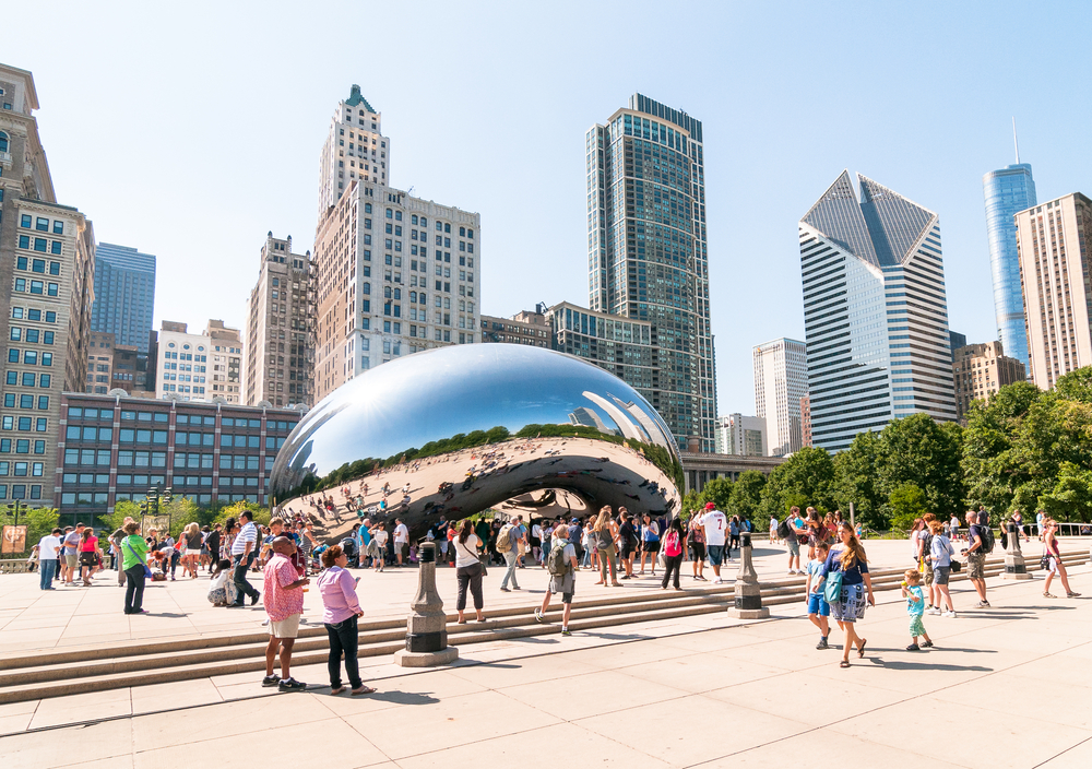 Tourists visiting Cloud Gate, one of the most unique and interesting sculptures in decades graces the promenade at Chicago Millennium Park.