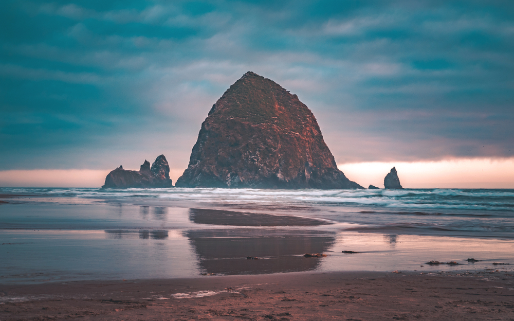 Summer sunset at Haystack Rock, an iconic monolithic rock at Cannon Beach in Clatsop County, Oregon, USA.