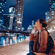 young woman wearing a light jacket at night admiring the buildings what to wear in chicago