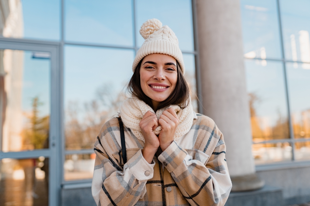 Caucasian woman wearing beige beanie and beige checked coat