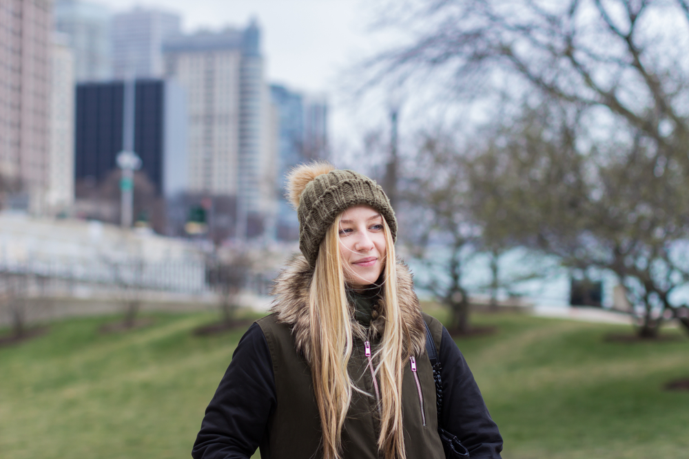 girl wearing a beanie and a brown black jacket with fur hoodie