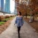 woman wearing blue top with stockings in a park with autumn leaves what to wear in chicago in the fall