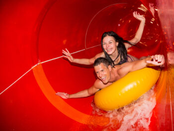 couple inside a covered red water slide indoor waterparks in the midwest