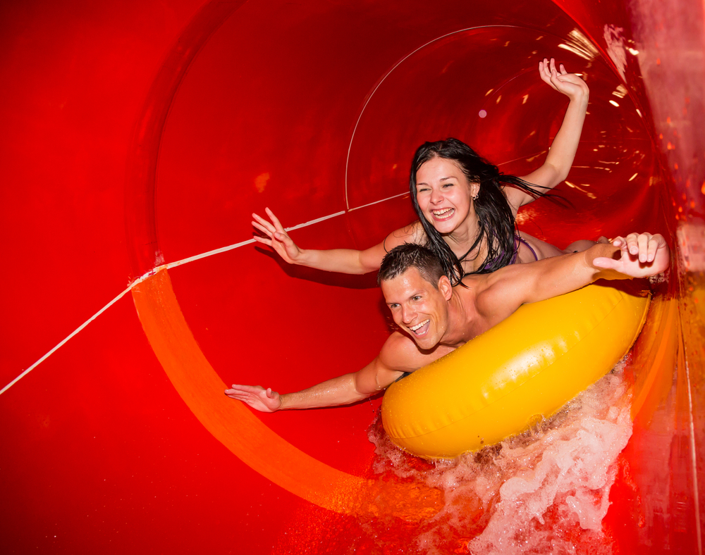 couple inside a covered red water slide indoor waterparks in the midwest