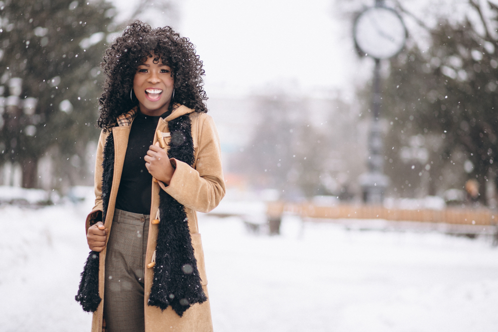 Afro american woman happy dressed for winter in long coat