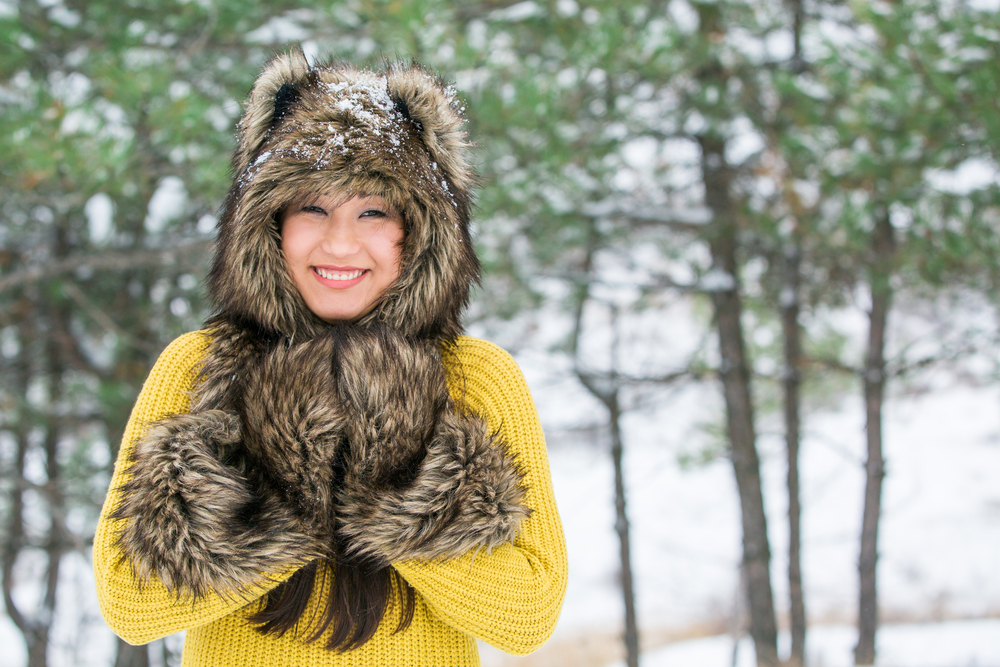 Asian girl in a cap from the skin of a wolf. Midwest winter packing guide