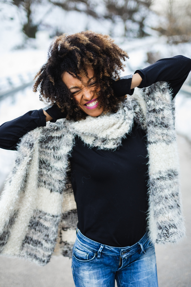 Young expressive black woman having fun in winter outdoor. Article is about your Midwest winter packing guide.