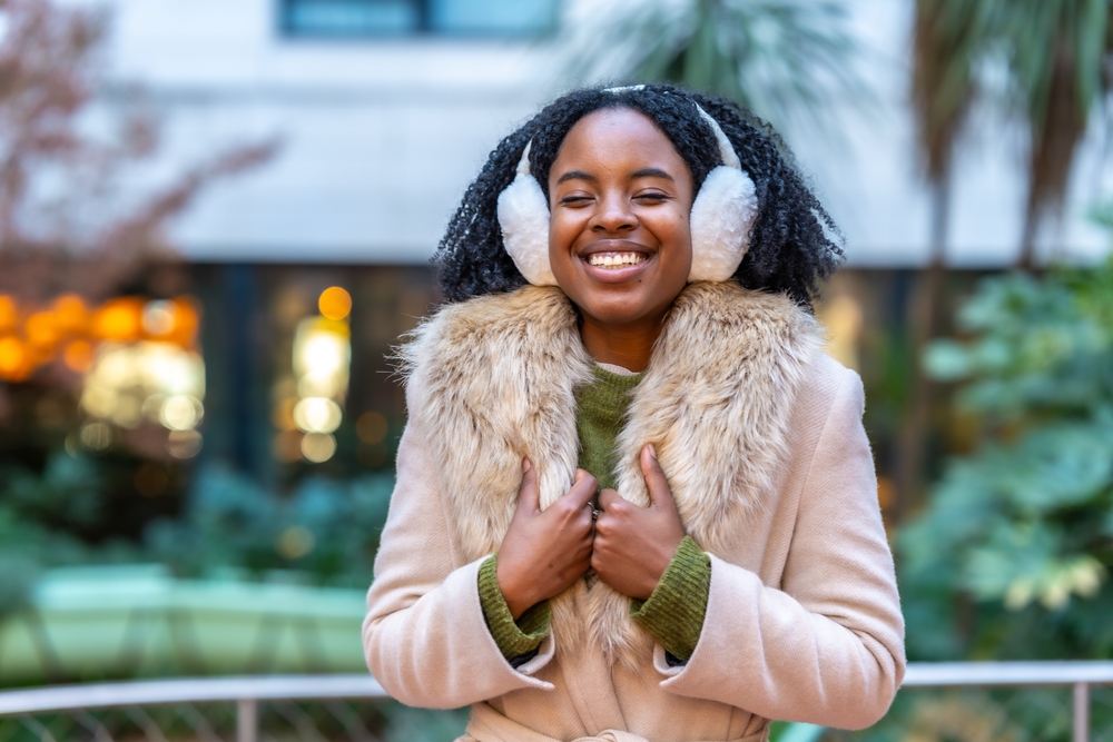 women smiling with cozy clothes on and ear muffs. Montana winter outfits.