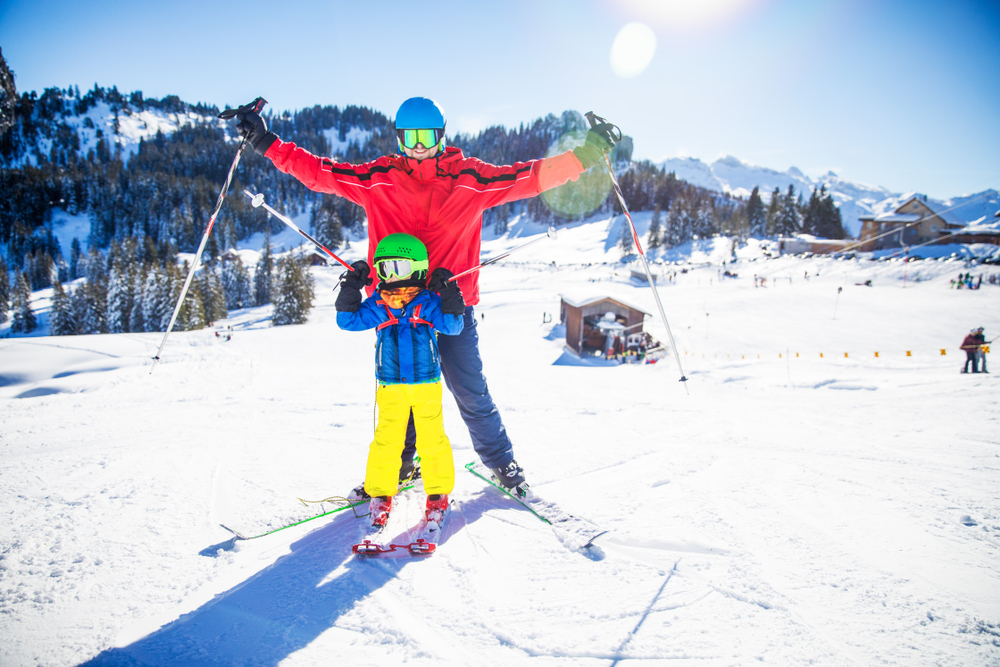 father and kid enjoying with skis all inclusive resorts in montana