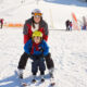 young woman and her kid enjoying on skis