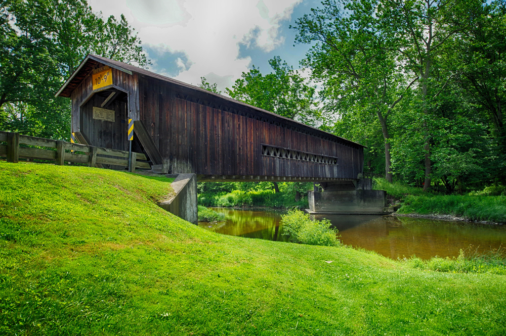 Benetka Road Bridge, Side View by a green bank. The article is about Ohio covered bridge road trip.