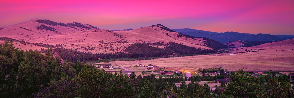 Helena Suburb Sunrise Skyline over the Helena National Forest and Avalanche Butte in Montana, USA: Tranquil mountain valley summer landscape with pink sky