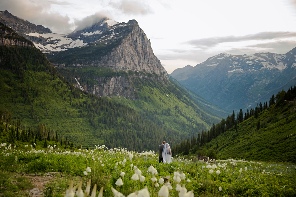 Wedding couple having their photos taken in glacier national park, rocky mountains, montana. The article is about Romantic Montana getaways.