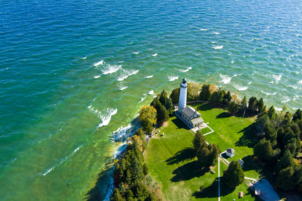The famous Cana Island lighthouse located next to lake Michigan in Door County Wisconsin with a drone. The article is about spring break in the Midwest.