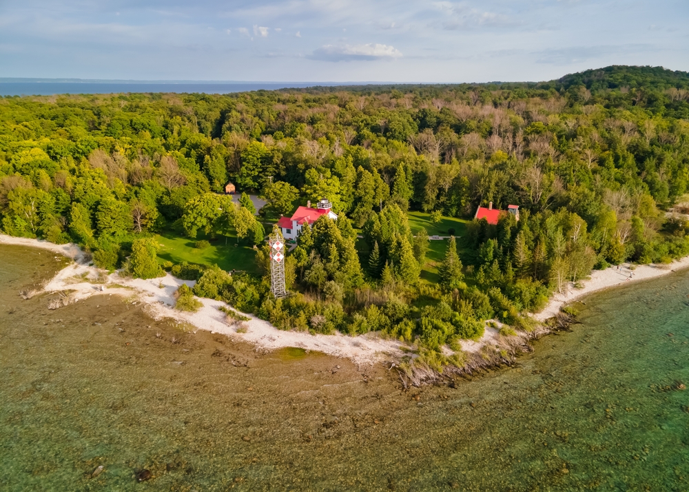 Aerial view of Leelanau state park, and Historic Grand Traverse lighthouse in Michigan . The article is about Northern Michigan Wine Country. 